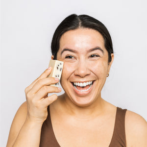 Model using Scrub & Butter Massaging Butter Bar on her face.